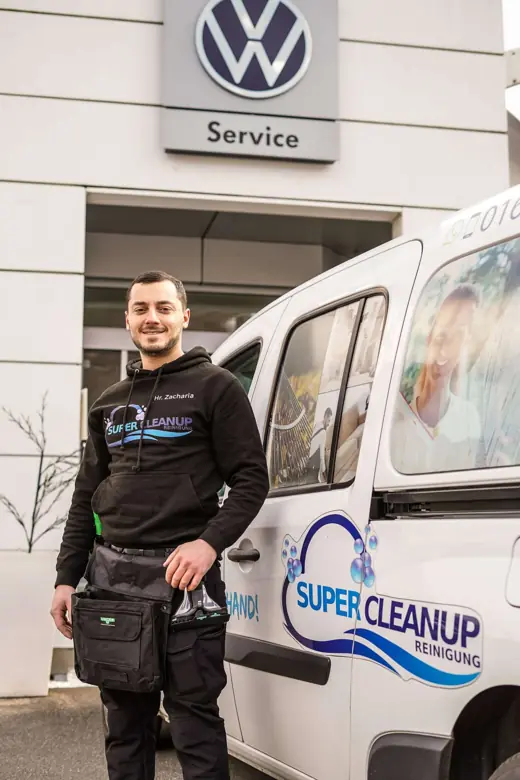 Mitarbeiter von SuperCleanup mit Arbeitstasche vor dem Einsatzfahrzeug